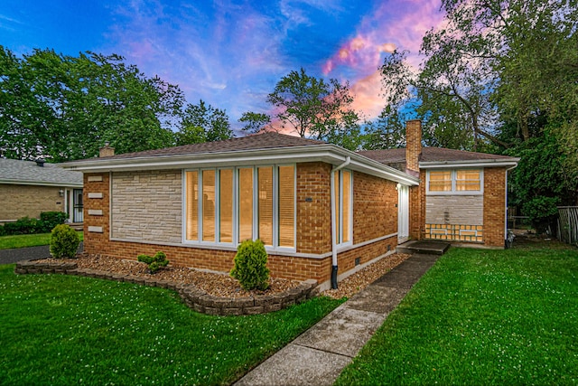 property exterior at dusk featuring a lawn