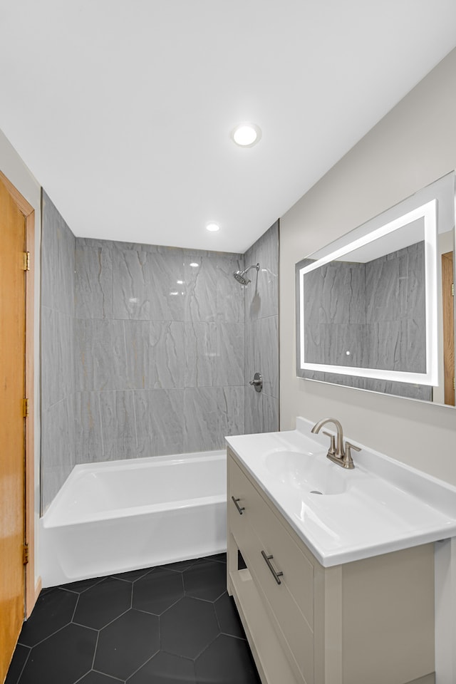 bathroom featuring tiled shower / bath, vanity, and tile patterned flooring