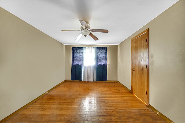 unfurnished room with ceiling fan and wood-type flooring