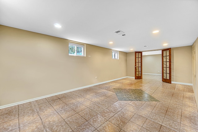 basement with french doors and light tile patterned floors