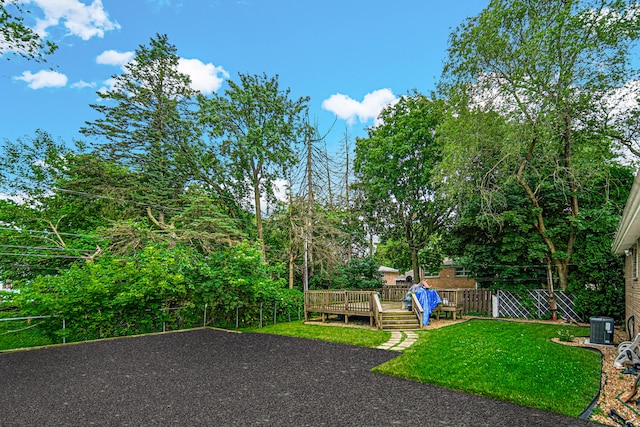 view of yard with a deck and central AC unit