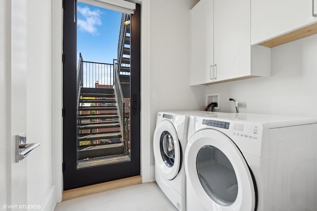 washroom featuring washing machine and dryer, cabinets, and light tile patterned floors