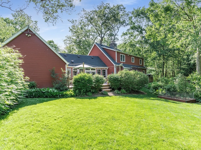 rear view of house featuring a lawn