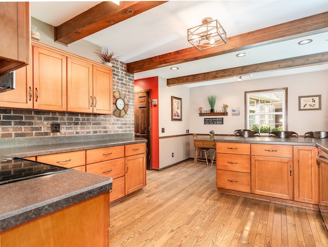 kitchen with light hardwood / wood-style flooring, beam ceiling, and tasteful backsplash