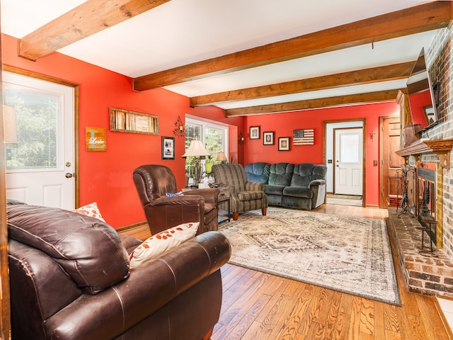 living room with a fireplace, beam ceiling, and hardwood / wood-style floors