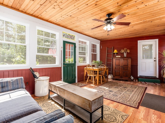 living room with wooden ceiling, wooden walls, ceiling fan, and light hardwood / wood-style flooring