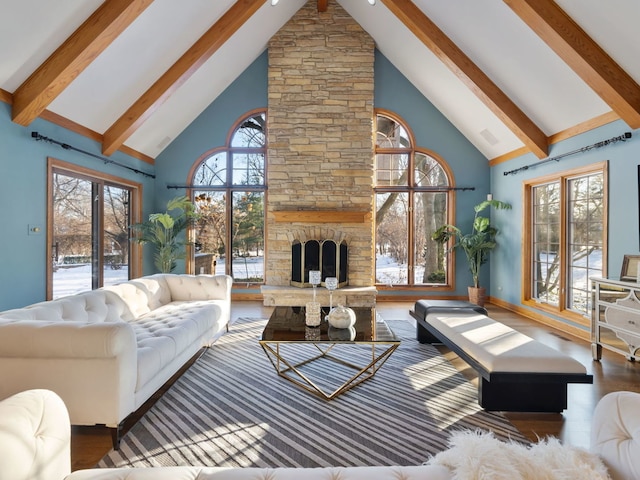 living room with a stone fireplace, hardwood / wood-style floors, and high vaulted ceiling