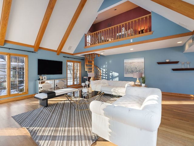 living room featuring high vaulted ceiling, beam ceiling, light hardwood / wood-style flooring, and a healthy amount of sunlight