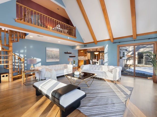 living room with high vaulted ceiling, beamed ceiling, and light hardwood / wood-style flooring