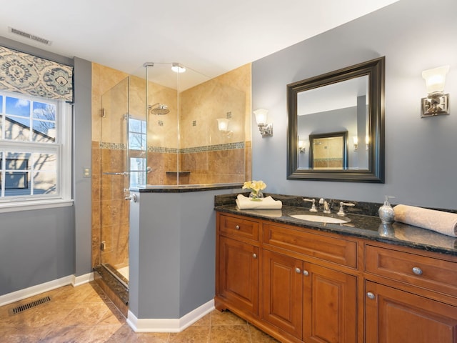 bathroom with walk in shower, tile patterned flooring, and vanity