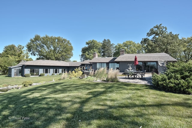 rear view of house featuring a patio and a yard