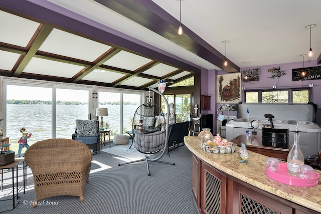 interior space featuring dark carpet, a water view, beamed ceiling, and plenty of natural light