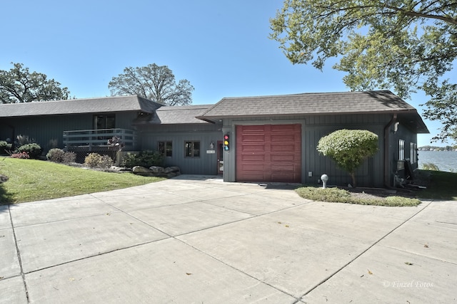 single story home featuring a water view, a front yard, and a garage