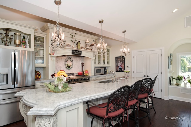 kitchen with hanging light fixtures, a kitchen island with sink, sink, and stainless steel appliances