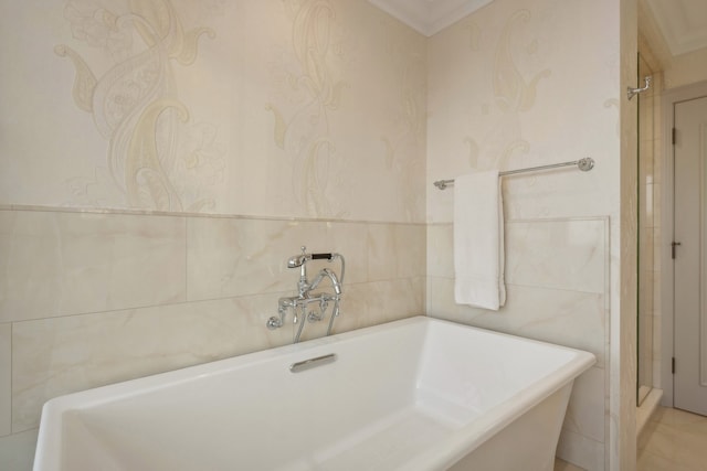 bathroom featuring ornamental molding, tile walls, and a bathtub