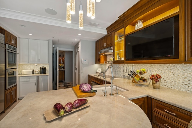 kitchen featuring light stone counters, pendant lighting, backsplash, and crown molding