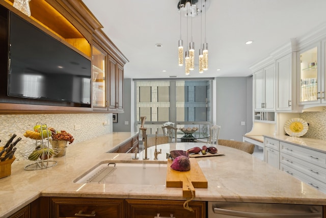 kitchen with backsplash, pendant lighting, light stone counters, and white cabinets