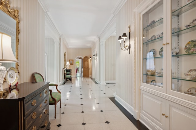 hallway featuring crown molding and decorative columns