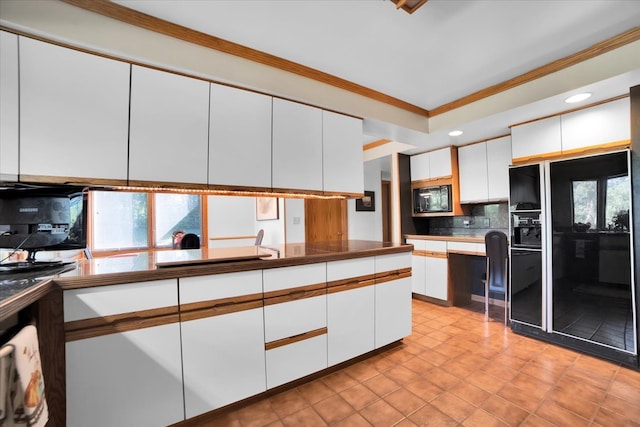 kitchen with white cabinets, stainless steel microwave, tasteful backsplash, and a healthy amount of sunlight