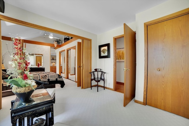 hallway featuring light carpet and lofted ceiling