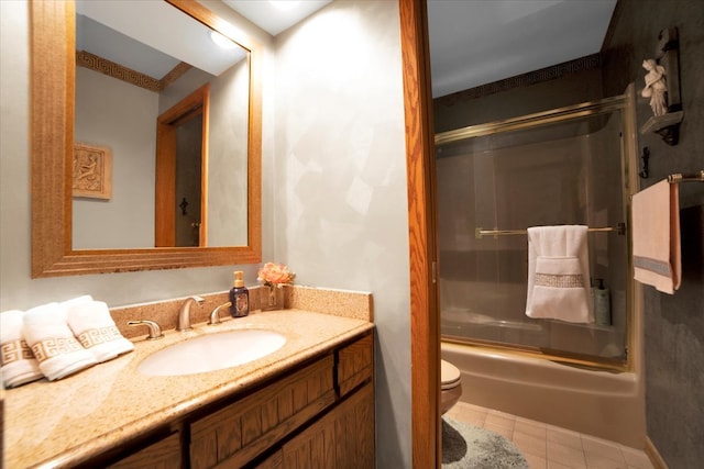 full bathroom featuring bath / shower combo with glass door, toilet, vanity, and tile patterned floors