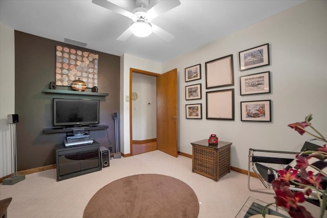 living area with ceiling fan and light carpet