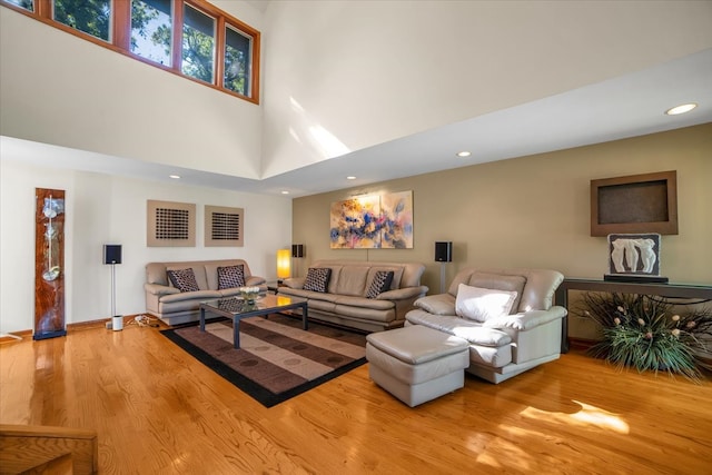 living room with wood-type flooring and a high ceiling