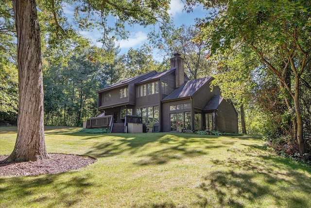 rear view of house featuring a lawn and a deck