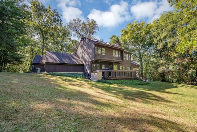 rear view of property featuring a yard and a wooden deck