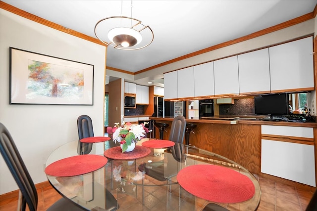 dining room with light tile patterned floors and crown molding