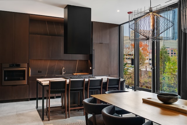 kitchen with tasteful backsplash, dark brown cabinets, a breakfast bar area, and appliances with stainless steel finishes