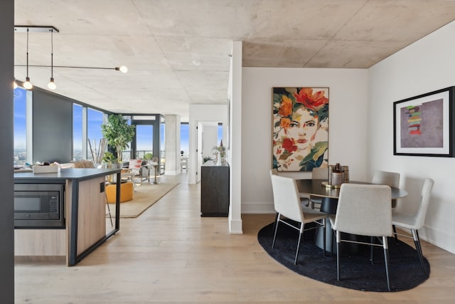 dining space with light hardwood / wood-style floors and floor to ceiling windows