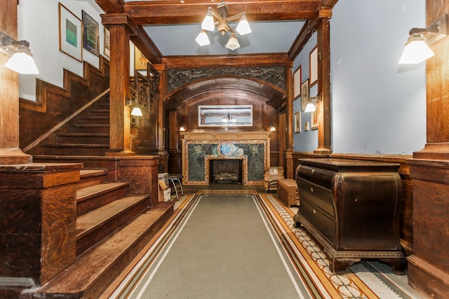 interior space featuring decorative columns, beam ceiling, and carpet flooring