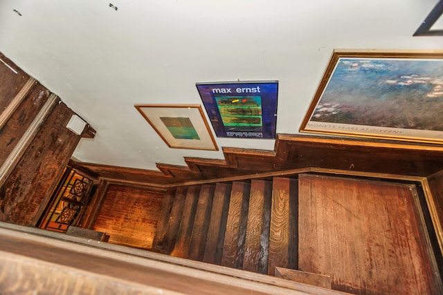 staircase featuring wooden walls