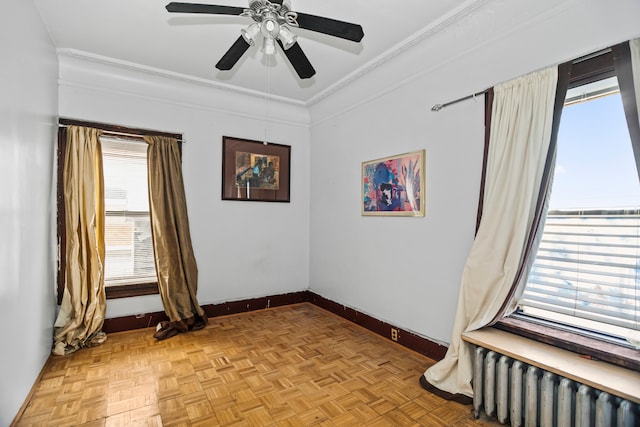 spare room featuring ornamental molding, light parquet floors, a wealth of natural light, and radiator