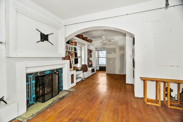 living room with wood-type flooring, radiator heating unit, and ceiling fan