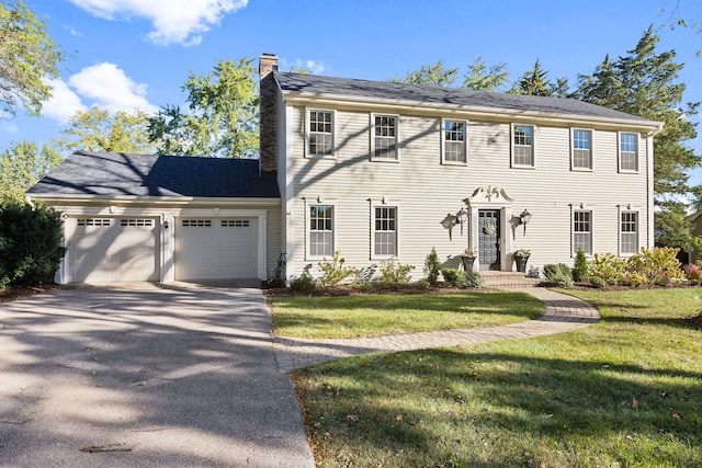 colonial home featuring a garage and a front yard