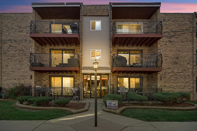 back house at dusk featuring a balcony