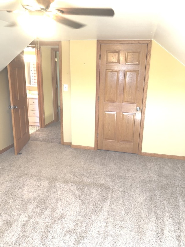 bonus room with vaulted ceiling, light carpet, and ceiling fan