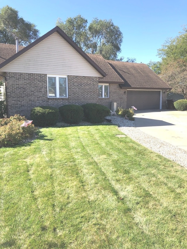 ranch-style home with a front lawn and a garage