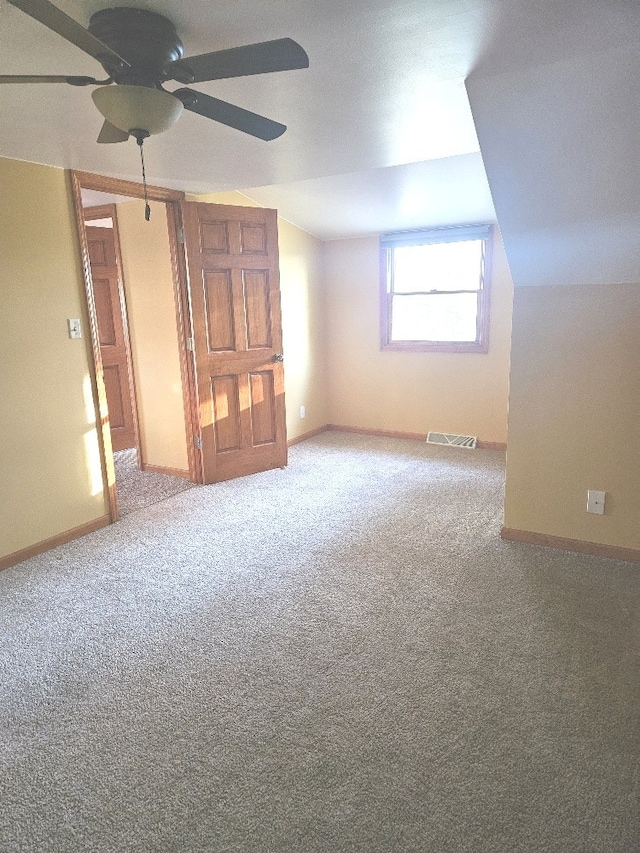 interior space featuring lofted ceiling, carpet, and ceiling fan