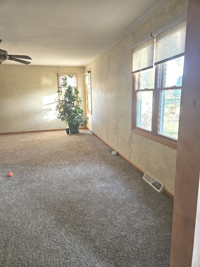 carpeted spare room featuring ceiling fan