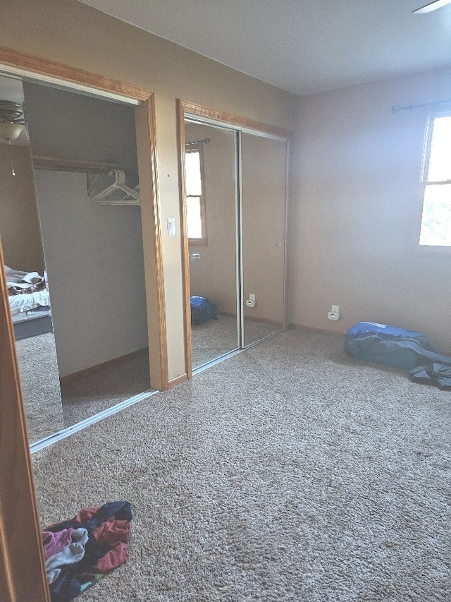 bedroom with multiple closets and carpet flooring