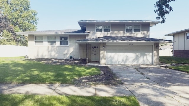 split level home with a garage and a front lawn