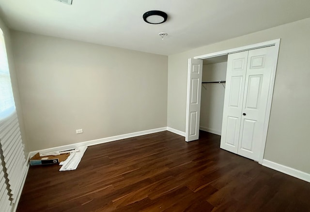 unfurnished bedroom with a closet and dark hardwood / wood-style flooring