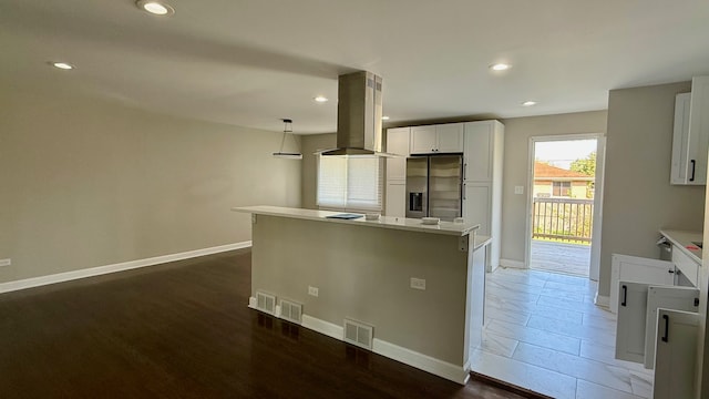 kitchen with island exhaust hood, dark wood-type flooring, hanging light fixtures, white cabinets, and stainless steel refrigerator with ice dispenser