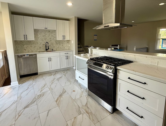 kitchen with white cabinets, sink, tasteful backsplash, island exhaust hood, and appliances with stainless steel finishes