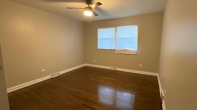 spare room featuring dark wood-type flooring and ceiling fan