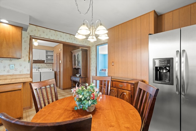 dining room with an inviting chandelier, washer and dryer, and light tile patterned flooring