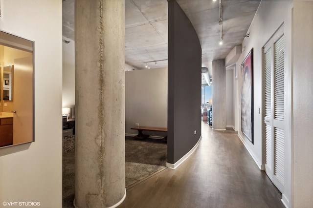 hallway featuring rail lighting and hardwood / wood-style flooring